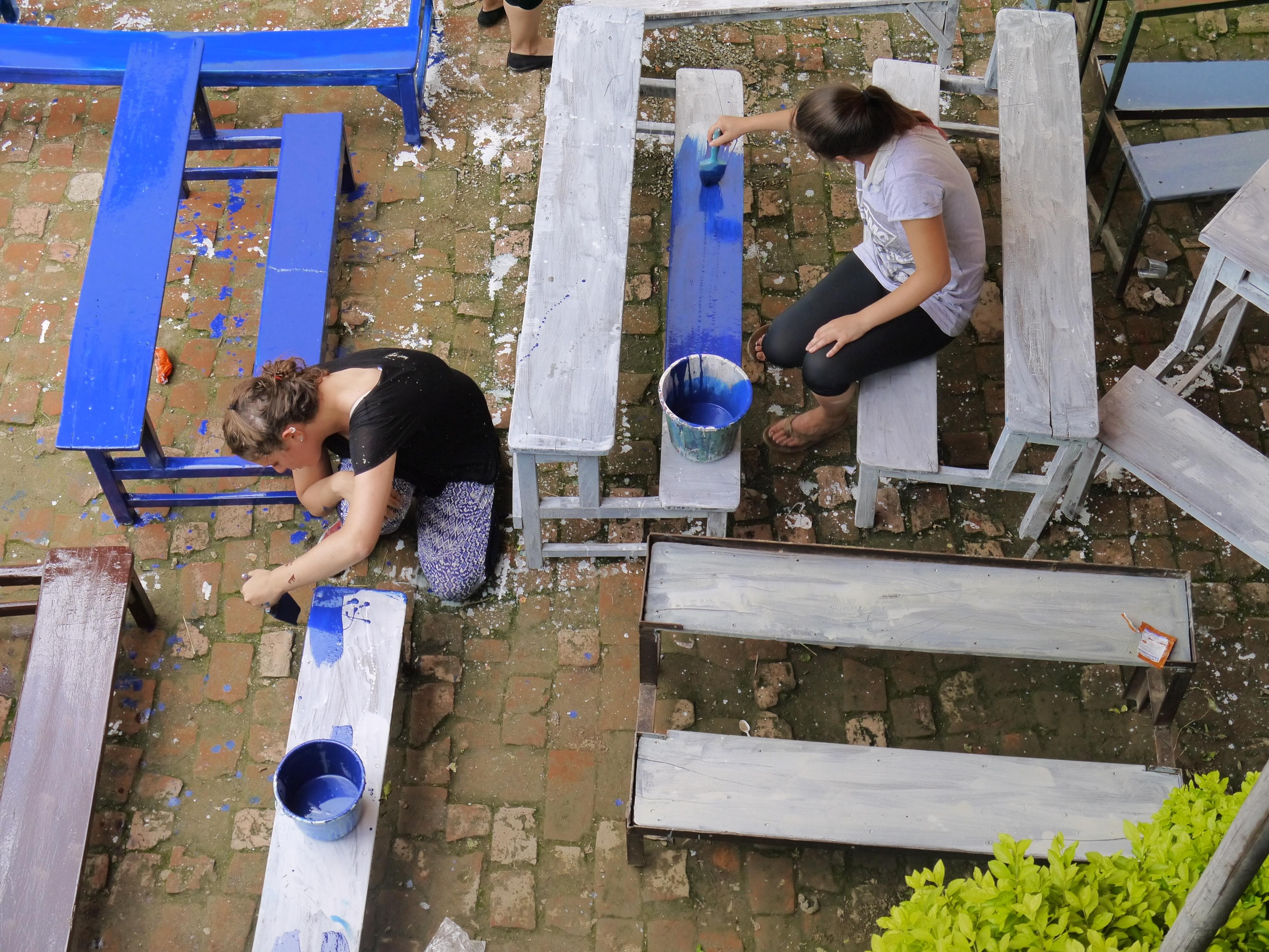 A group of HIV/Aids volunteers in Nepal assist with renovation work at their care placement. Projects Abroad HIV/Aids volunteers in Nepal paint chairs and desks at their Childcare placement.